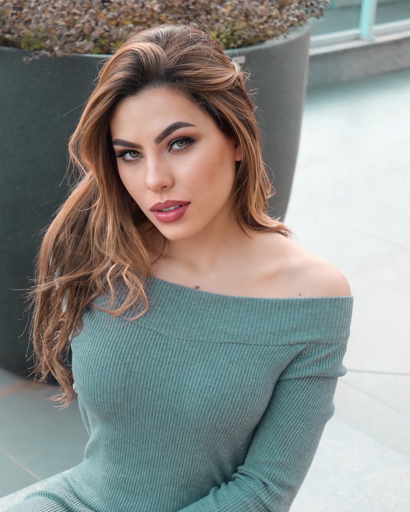 Mujer con vestido de punto verde salvia de cuello caído